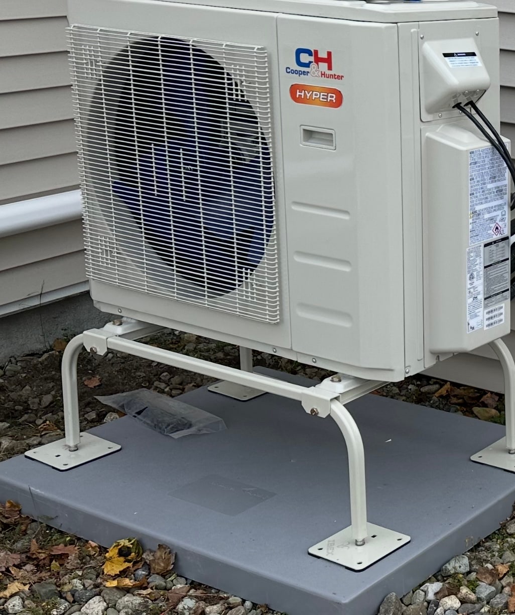 Cooper and Hunter Hyper cold climate heat pump mounted on a stand beside a home by Harbormen Heating and Cooling